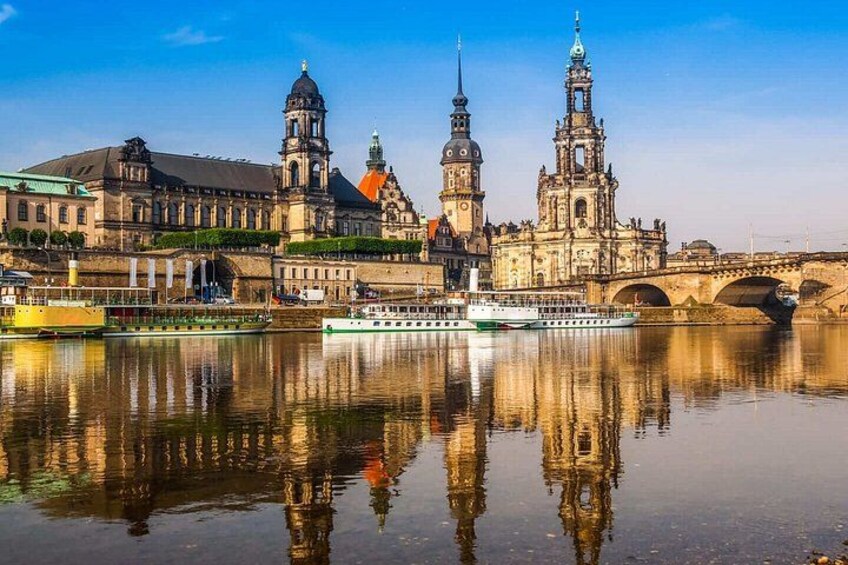 A river with a boat, a bridge, and historic buildings with towers. 2