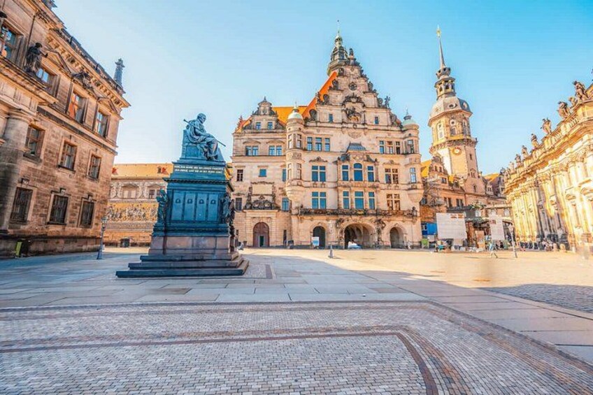 A historic building with ornate architecture, a central statue, and cobblestone pavement. 5