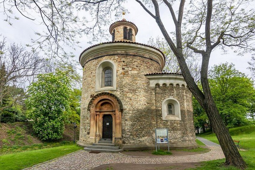 A stone building with a round tower, arched entrance, and a small window. 5