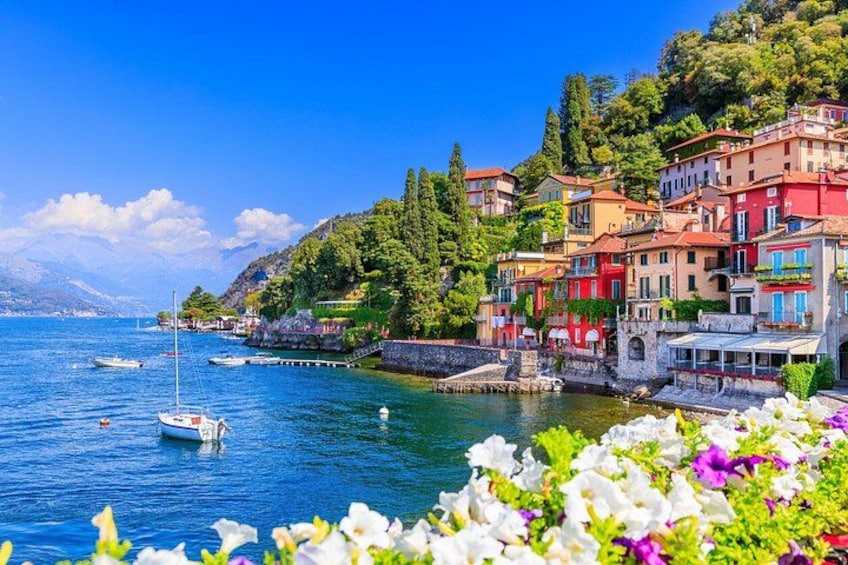 A coastal town with colorful buildings, a clear blue sea, and boats. 1