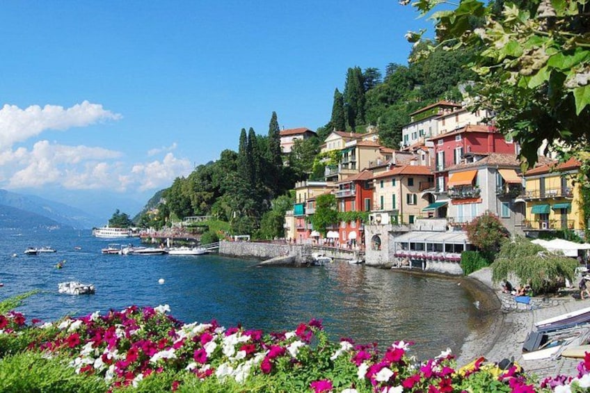 A coastal town with colorful buildings, a waterfront promenade, and boats on the sea. 5