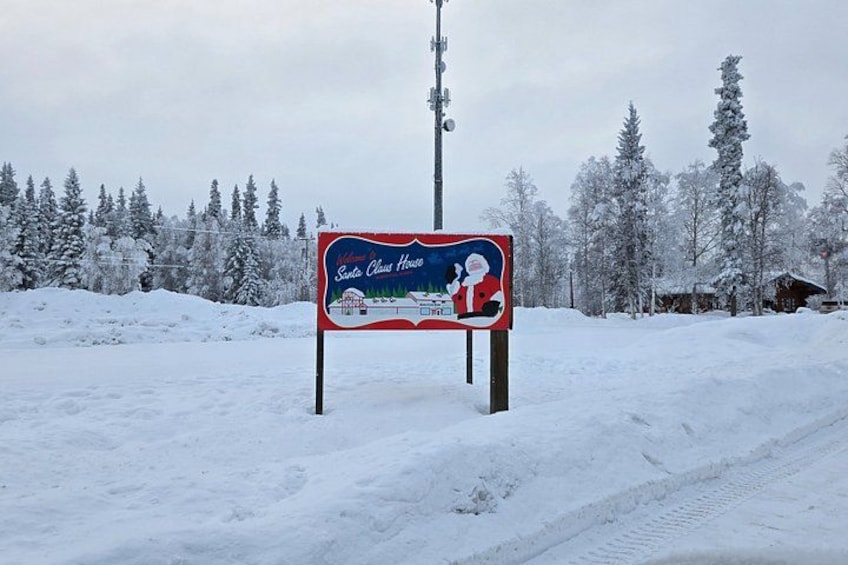 A snow-covered landscape with a sign for 'Santa Claus House.' 1