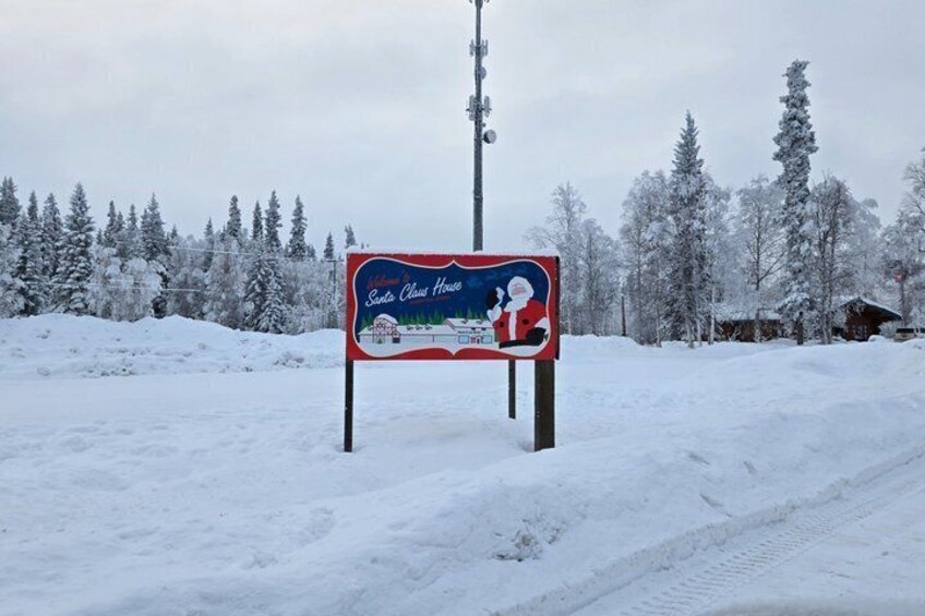 A snow-covered landscape with a sign for 'Santa Claus House.' 1