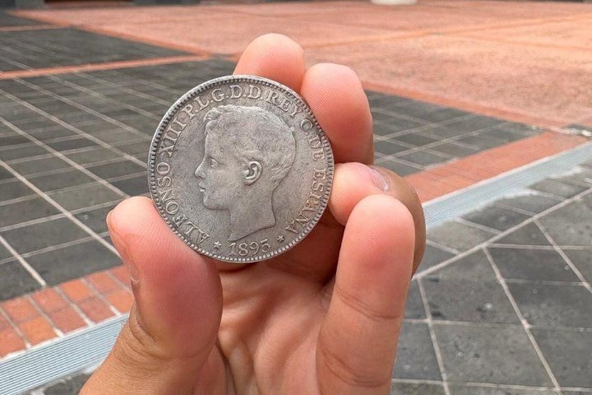 A hand holding a coin with the inscription 'AUGUSTUS' and the year '1895'. 3