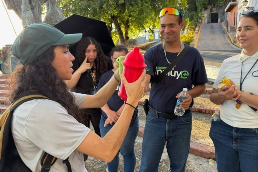 A person holding a red object, possibly a toy, and another person holding a water bottle. 1