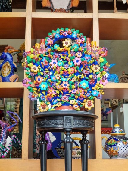 A colorful floral arrangement on a shelf with various decorative items. 4