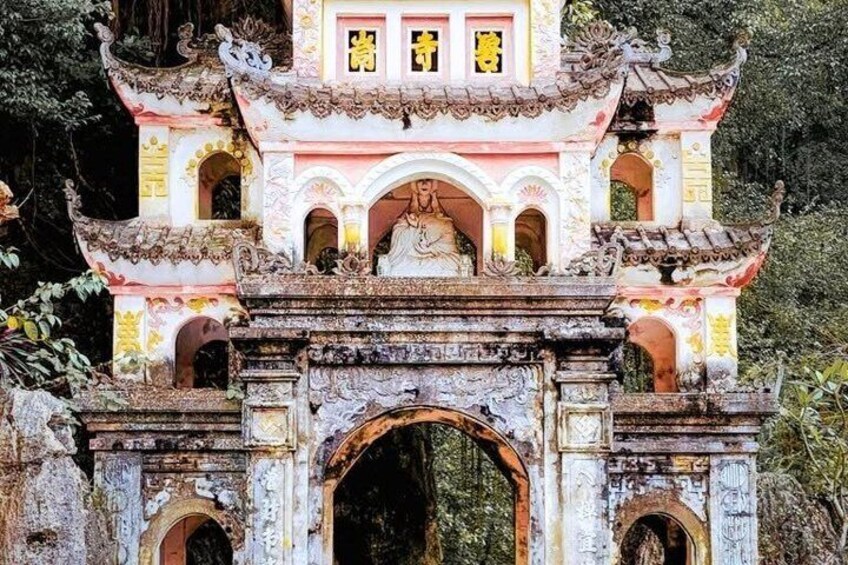 A traditional Chinese gate with intricate carvings and a statue. 4
