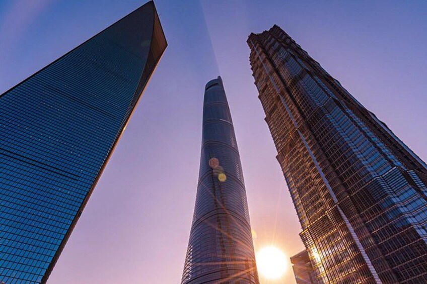 Three skyscrapers with the sun setting in the background. 3