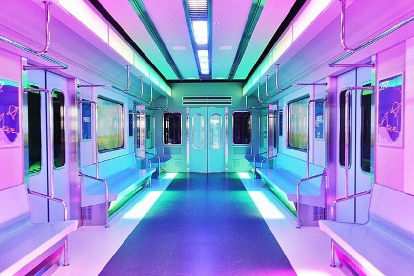A brightly lit train carriage with neon blue and purple lighting, windows, and doors. 4
