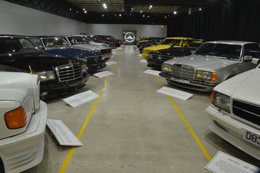 A row of luxury cars parked in a showroom. 2