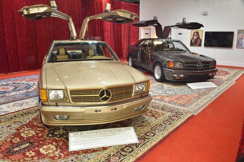 A beige Mercedes-Benz with extended rear doors and a sign indicating it is a 500 SEL Gullwing by Styling Concept. 1