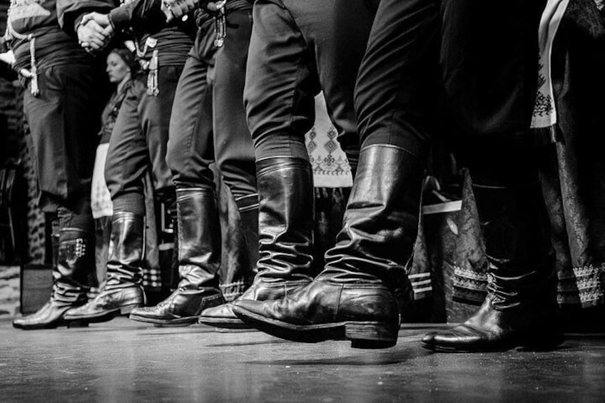 A group of people standing in a line, wearing boots and trousers. 5