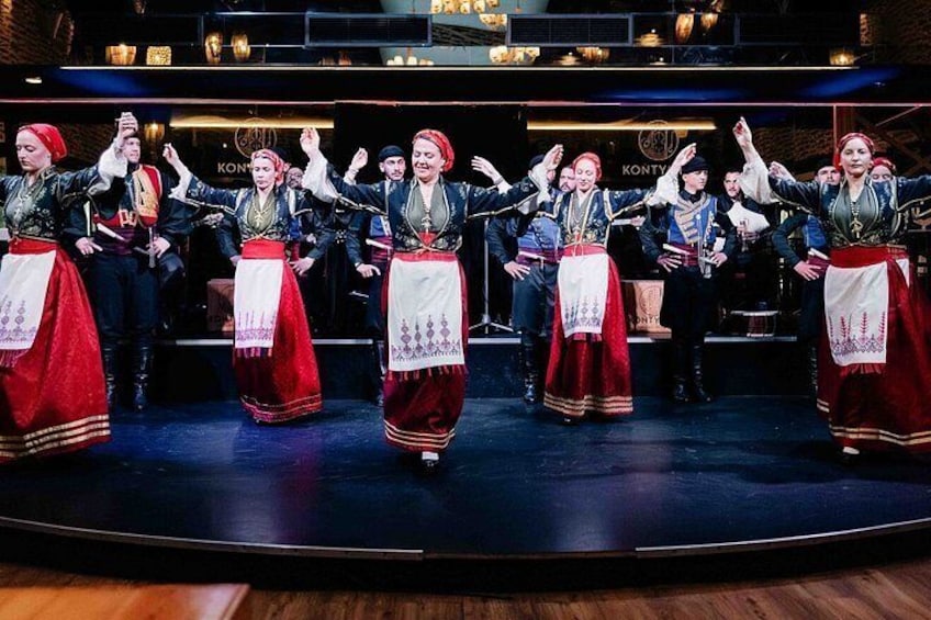 A group of people performing a traditional dance on a stage with a dark background and a sign that reads 'KONTV'. 1