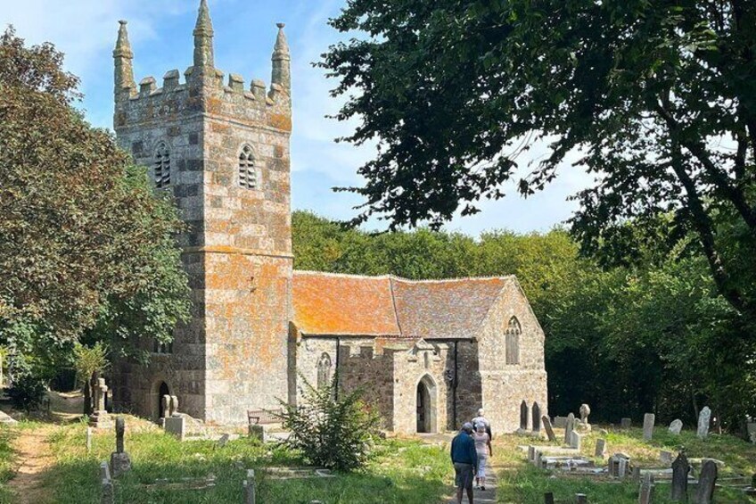 A historic church with a tall tower and a stone building with a tiled roof. 2