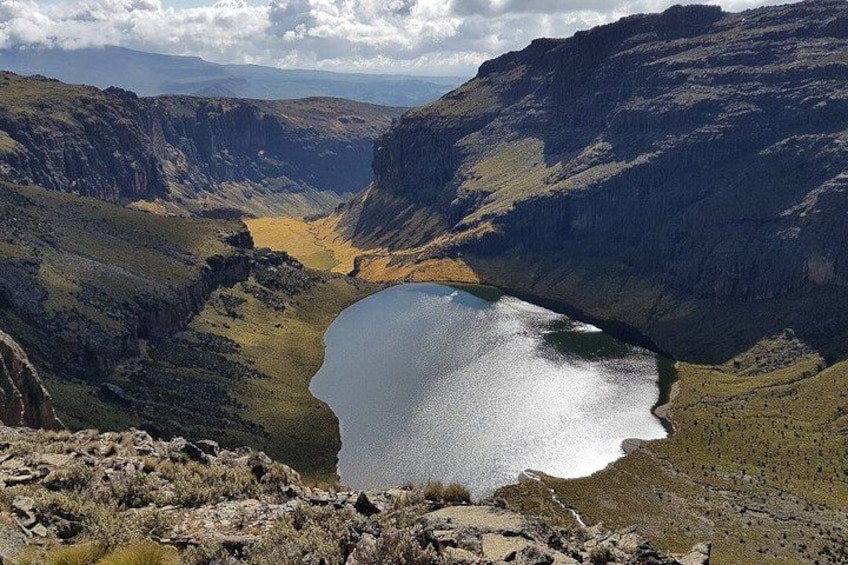 A mountainous landscape with a lake surrounded by cliffs. 5