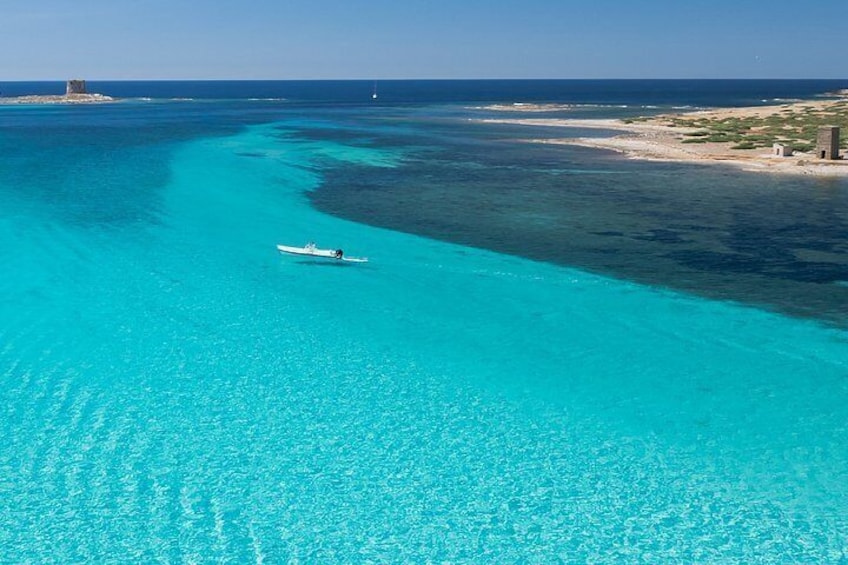 A boat on turquoise waters, a sandy beach, and a small structure in the distance. 3