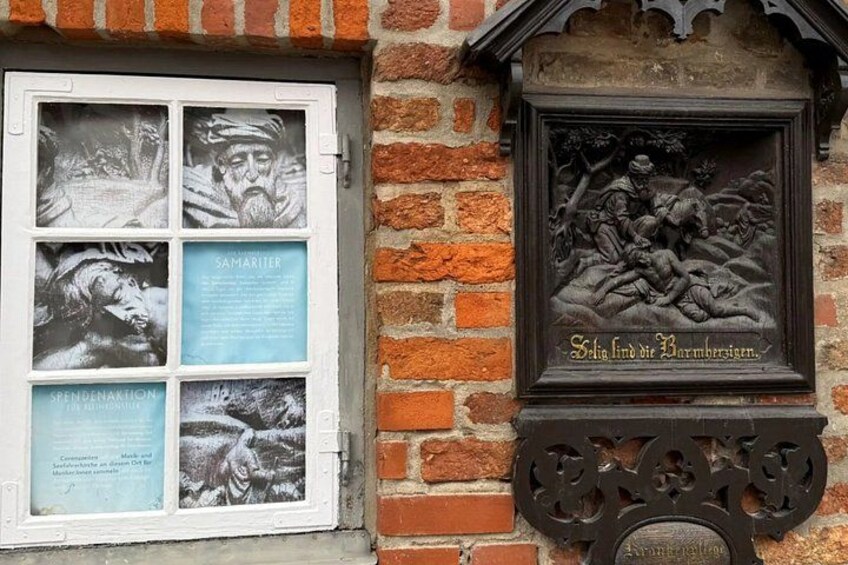 A brick wall with a window displaying historical photos and a relief sculpture. 3