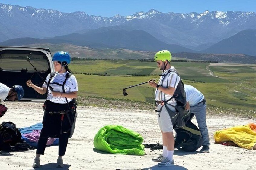 Two people with helmets and harnesses, a van, and a mountainous landscape. 5