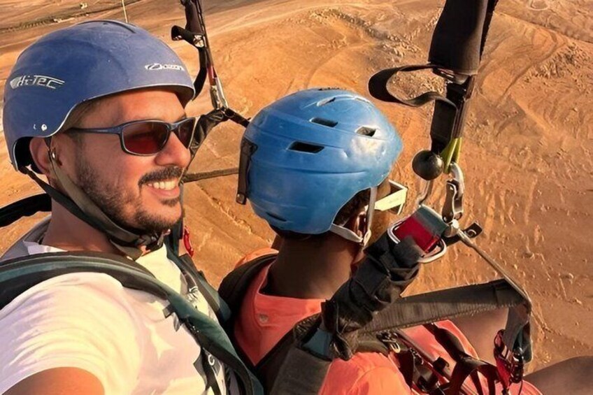 Two people wearing helmets and harnesses, preparing for a ride. 3