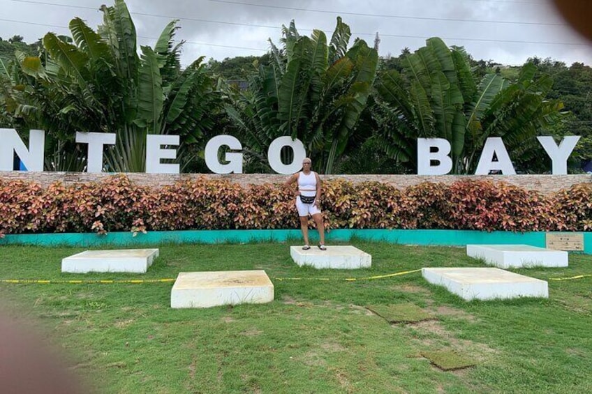 A person standing on a platform with the words 'NTEGOBAY' in the background. 2