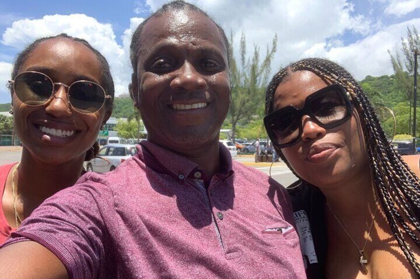 Three people taking a selfie in a parking lot with trees and a clear sky in the background. 4