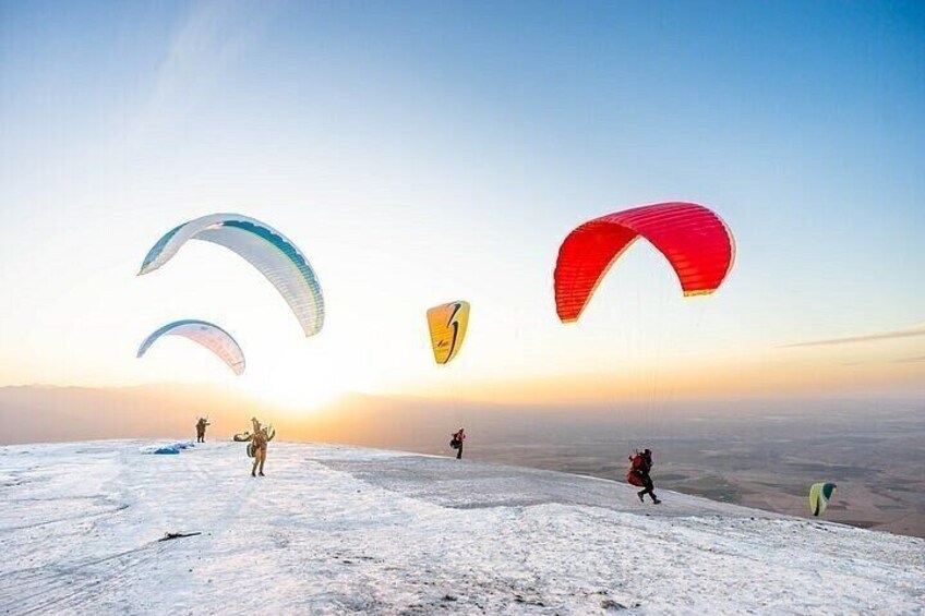 A snowy landscape with people paragliding. 2