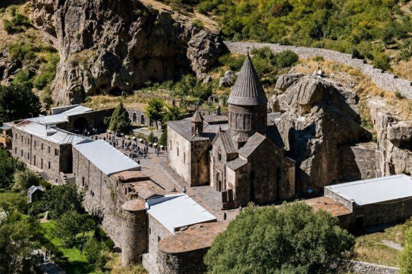 A historic town with stone buildings, a church, and a castle-like structure. 1