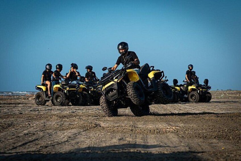 A group of people on ATVs on a sandy terrain with a clear sky. 5