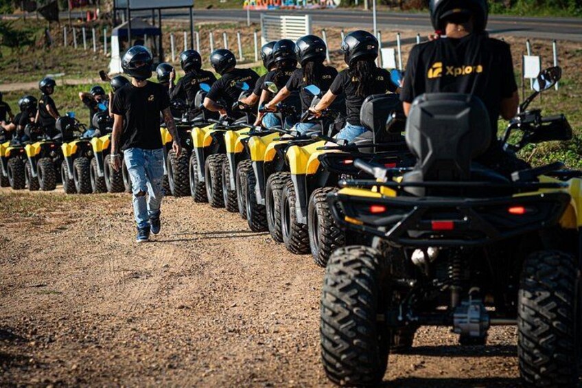 A group of people on ATVs lined up on a dirt path. 2