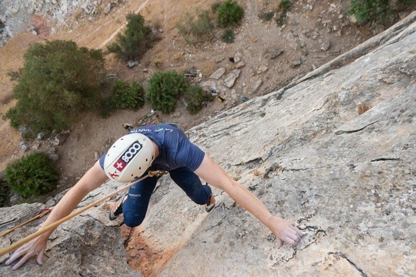 A person rock climbing on a steep rock face. 4