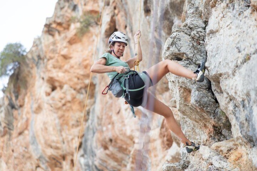 A person rock climbing on a rocky cliff. 1