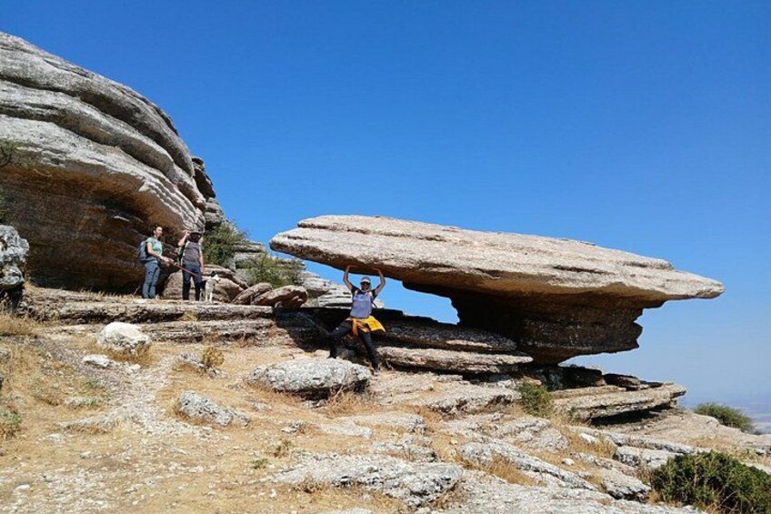 A rocky landscape with large boulders and a clear blue sky. 4