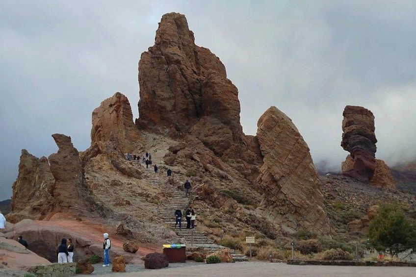 A rocky mountain landscape with a staircase leading up to a peak. 5