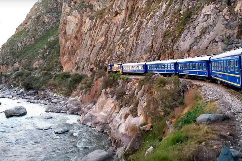 A train traveling along a mountainous track with rocky terrain and a river. 3