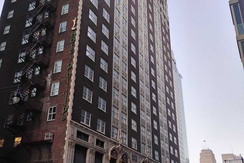 A tall brick building with multiple windows and a fire escape. 3