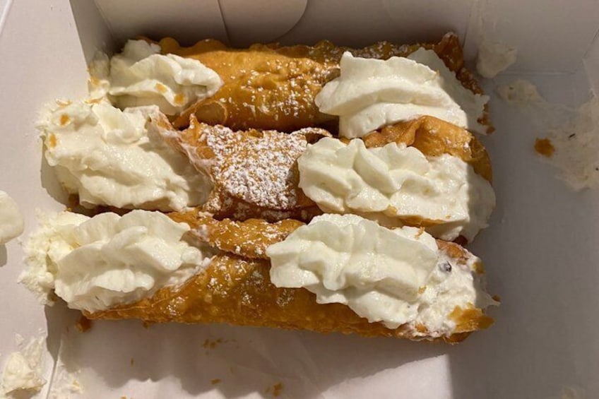 A box of pastries with whipped cream and powdered sugar. 3