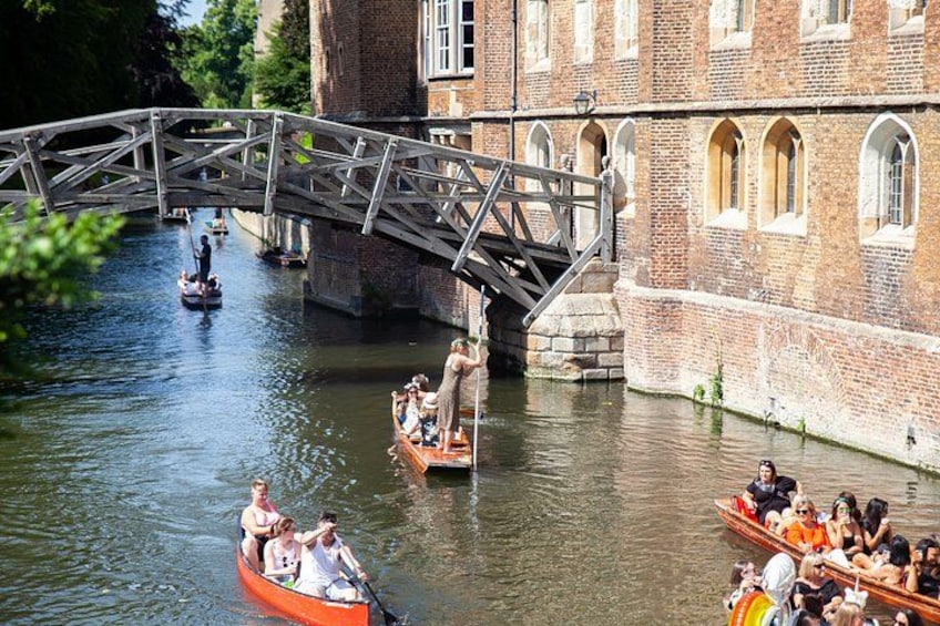 A river with boats, a bridge, and a historic building. 5