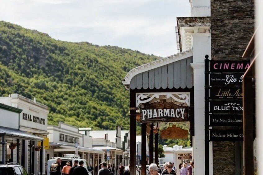 A street with shops, including a pharmacy, and a cinema. 2