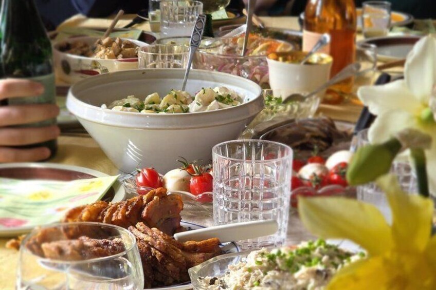 A table with various dishes, including a large bowl of salad, plates of food, and glasses of water. 1