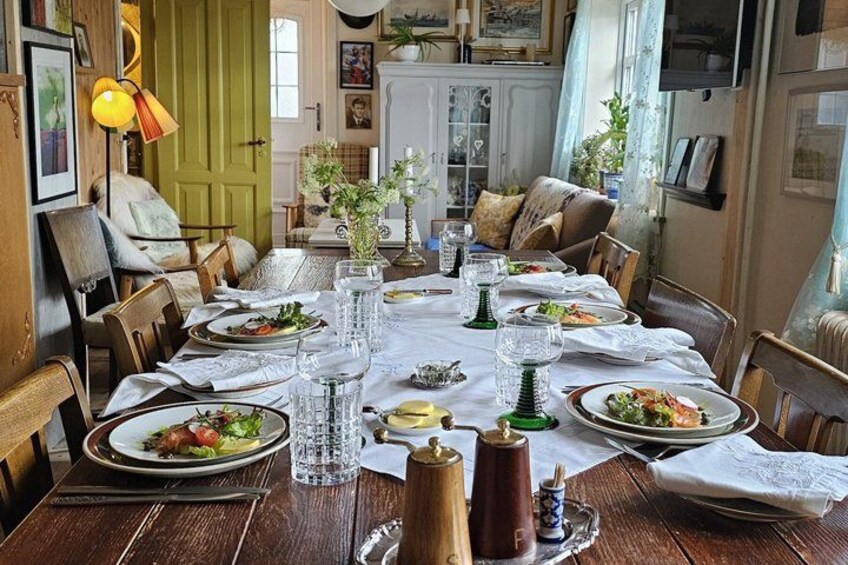 A wooden dining table set with plates, glasses, and a centerpiece. 5
