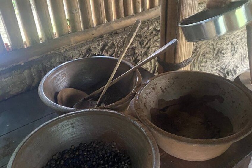 Three large metal pots and a wooden bowl filled with beans, placed on a rustic surface. 4
