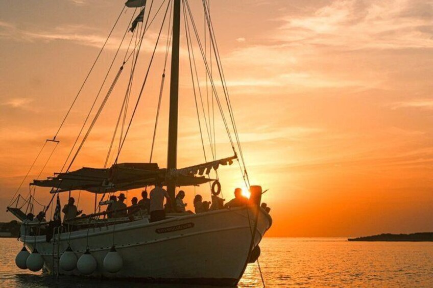 A sailboat with passengers at sunset. 1