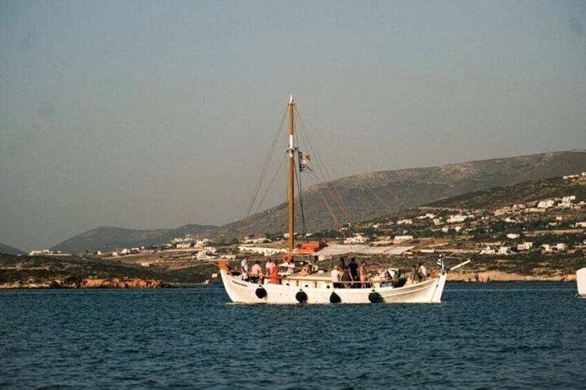 A sailboat on calm waters with a coastal village in the background. 3