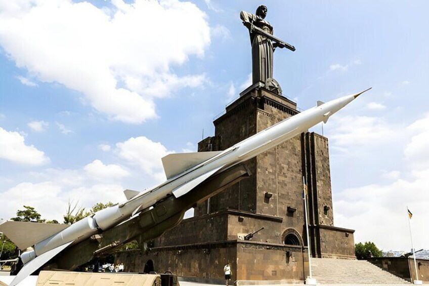 A missile on a launch platform with a statue on top. 5