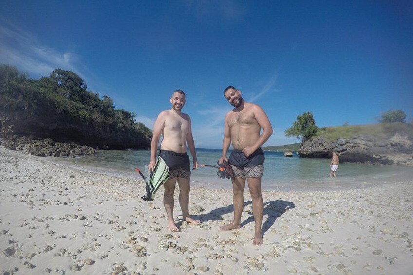 Two people on a sandy beach with clear skies and calm water. 5