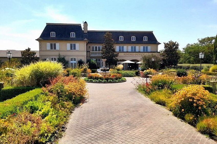 A landscaped garden with a paved walkway leading to a building with a sign that reads 'KENDALL-JACKSON.' 3