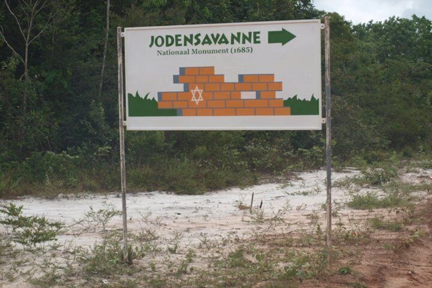 A sign for Jodensavanne National Monument (1685) with an arrow pointing to the right. 1