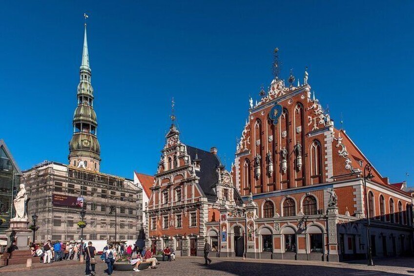 En historisk plads med en markant kirke, et højt spir og detaljeret arkitektur. 3