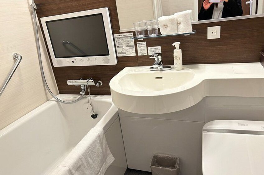A bathroom with a bathtub, sink, mirror, and a toilet. 4