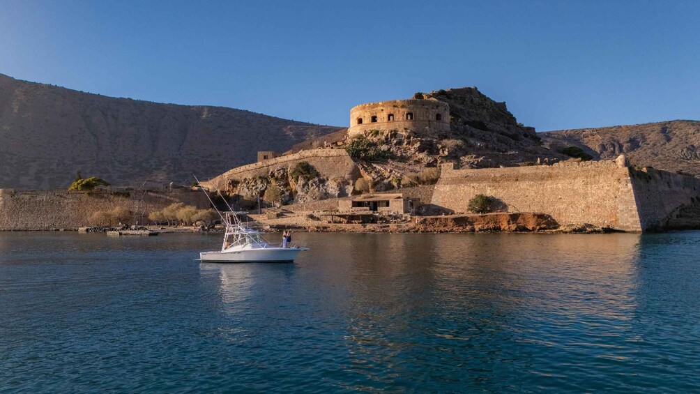 A boat on calm water, a castle on a hill, and a clear blue sky. 3